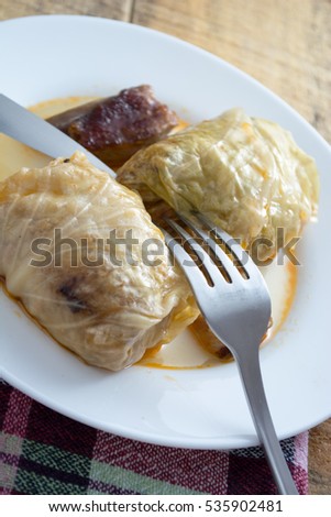Serbian sarma (stuffed cabbage rolls) served on the white plate on wooden table