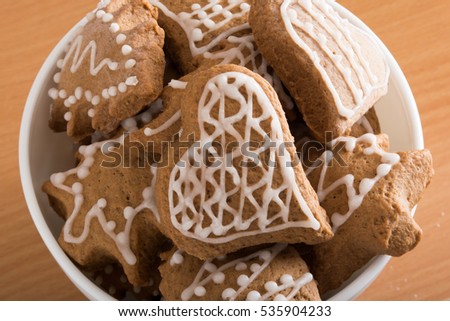 Decorated gingerbread cookies in white bowl