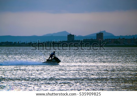 man with sea scooter at sunset, water jet rider, jet skiing, Baku Azerbaijan