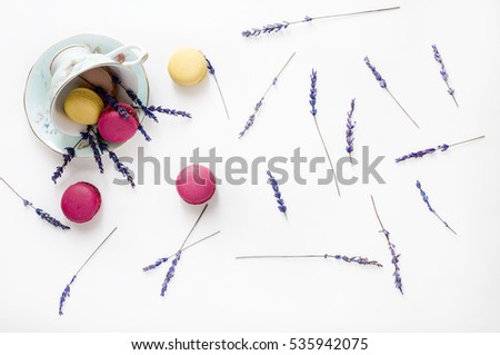 Creative composition with cup, macarons cookies and lavender flowers on white background