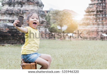 Cute girl taking a selfie with smart phone on archaeological background, concept travel and leisure.