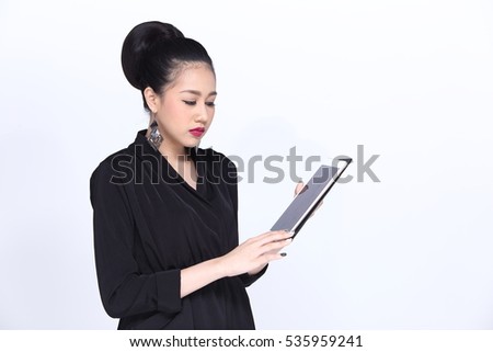 Business Working Woman Model in executive look, Black Dress with Asian look Red lip and earring, holding tablet and serious look. Grey background in studio lighting, copy space for text and logo