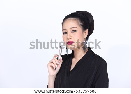 Business Working Woman Model in executive look, Black Dress with Asian look Red lip and earring, hold silver stick metallic in hand. Grey background in studio lighting, copy space for text and logo