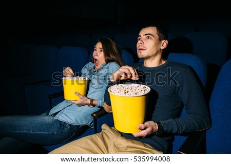 Cinema Day. Young couple watching a thriller movie in cinema. Date.