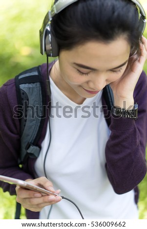 pretty women in the park listening music