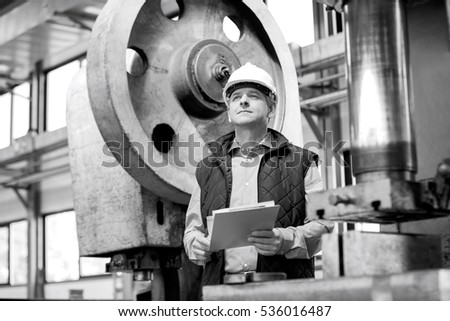 Male supervisor holding clipboard in metal industry