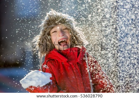 Happy boy playing in snow, winter games 
