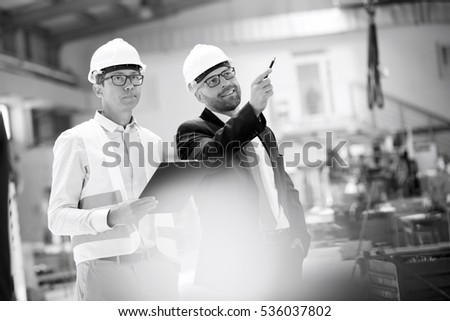 Mid adult male supervisors having discussion in metal industry