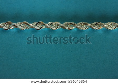 Silver chain on blue paper background