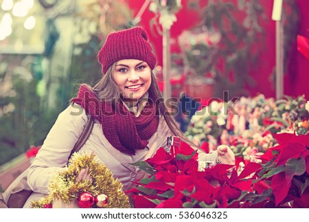 Portrait of female customer 25s choosing eucalyptus decorations for Christmas outdoor