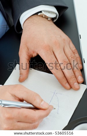 Hands of businessman drawing graph on paper napkin with pen.