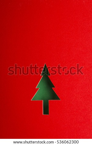 Christmas tree cutting design on red paper background