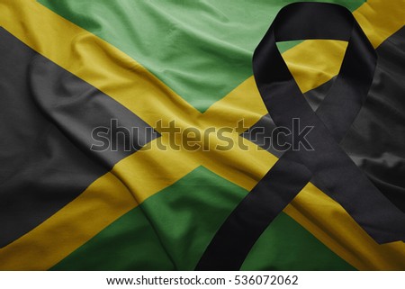 waving national flag of jamaica with black mourning ribbon