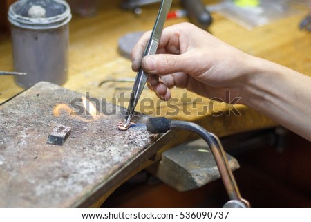 Master soldering jeweller. Picture of hands and product close up.