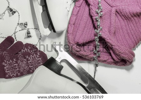 white figure skates, pink scarf and mittens, silver garland on a white background