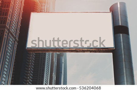 Mock up of blank horizontal white advertising billboard in Dubai with residential and office modern contemporary skyscrapers and sky behind