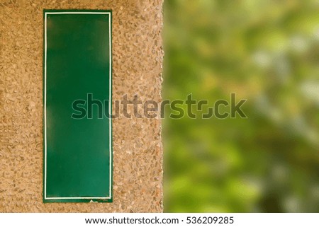 Blank green signboard on corner of the stone building