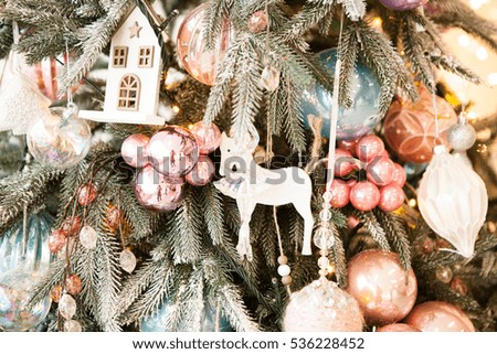 Christmas tree decorated with glass and wooden vintage toys in pastel colors 