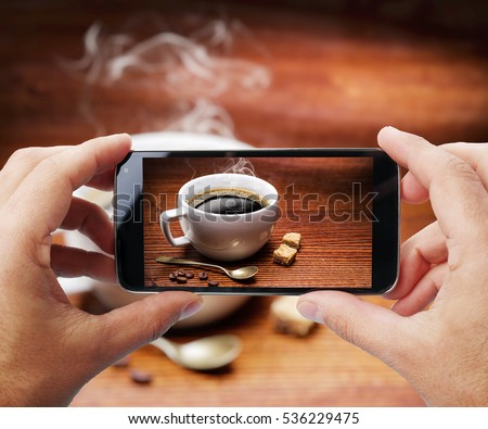 Taking photo of cup of coffee by smartphone. Closeup view of  process. File contains clipping paths for smartphone and hands and  picture on it.