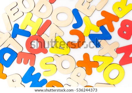 English alphabet made of natural yellow wood randomly scattered on a white background. Latin letters. Color letters.
