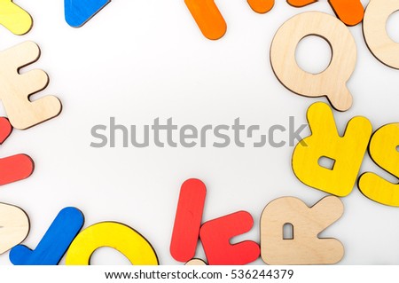 English alphabet made of natural yellow wood randomly scattered on a white background. Latin letters. Color letters.