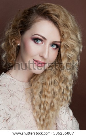 Beautiful portrait of gorgeous woman with blonde curly hair, fashion make-up, glowing healthy clean skin, festive look. 