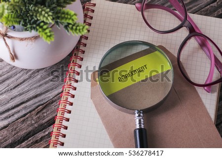 Business Concept : AGREEMENT written on envelope with wooden background