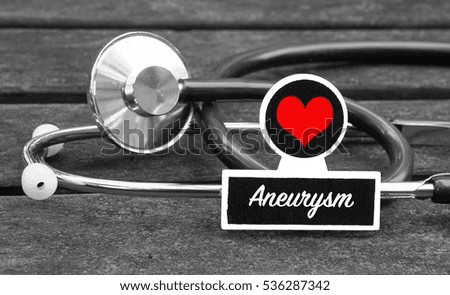 Aneurysm word written on blackboard with Stethoscope on wooden background - Medical Concept                    