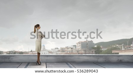 Businesswoman on building roof . Mixed media