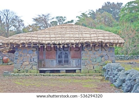 a traditional thatched roof house, korea. Non english text means "do not stand"