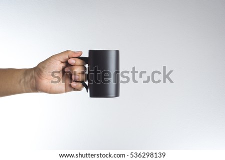 Hand hold dark cup of drink on white background