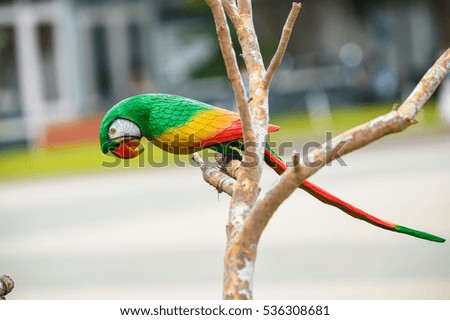 Colorful Ceramic bird statue on water pots in the garden blur background