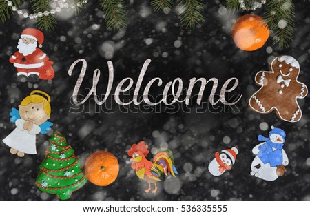 Xmas composition with text Welcome on school blackboard and the Christmas decorations, toys (Santa Claus, Angel, a rooster, a snowman, a penguin) and tangerine
