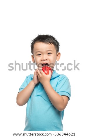Asian baby boy holding and eating red apple, isolated on white