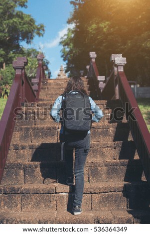 Rear view of young attractive woman tourist with backpack coming to shoot photo at ancient phanom rung temple in thailand.
