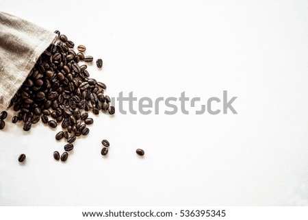 Fried grains of coffee on a white background, coffee in a fabric bag
