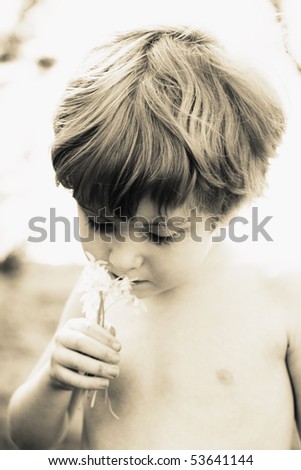 Young boy smelling flowers (shallow depth of field)
