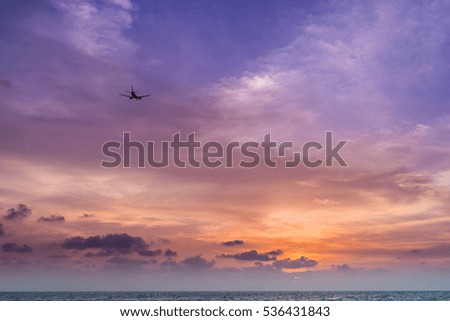 silhouetted airplane with beautiful twilight sky, shooting from beach and low light.natural summer. Thailand