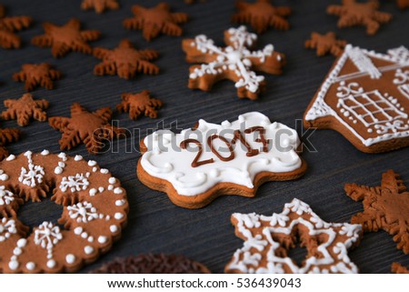 Xmas cookies in a different shape of snowflakes with 2017 numbers on a dark wooden background.  