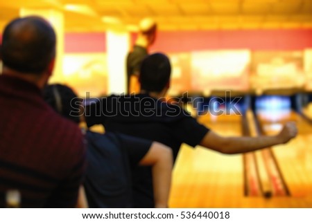 Celebrating good shot in bowling game as a blurred background.