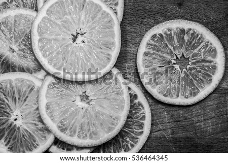 Sliced juicy tangerine on a wooden surface. Texture mandarin. Background of mandarin. Black and white photo
