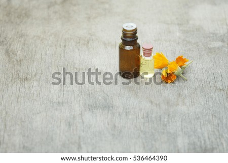 Calendula oil in a glass jar on an old wooden table, background, place for text, selective focus