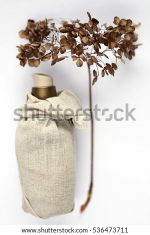 Serum in sackcloth and dry flower hydrangea on a white background. organic cosmetics concept 2