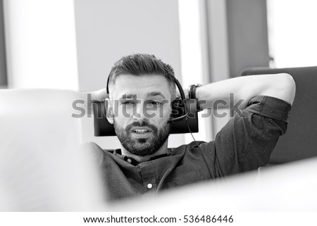 Mid adult businessman using headset in office