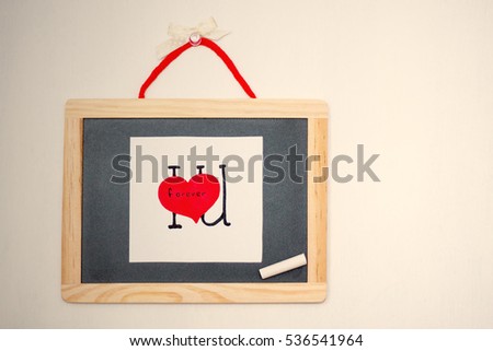 I love you forever card. Empty copy space for text. Wooden background with filter soft light. Little Blackboard with hand drawn card I love U forever. Infinite Love concept. Cute sweet love picture.