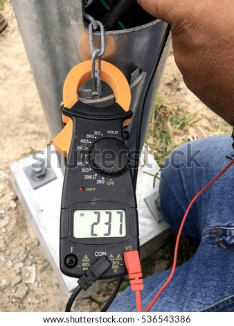 Technician use clamp meter to measure voltage at street lighting