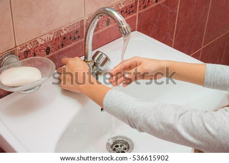 Child Framed hand under the stream of cold water Royalty-Free Stock Photo #536615902