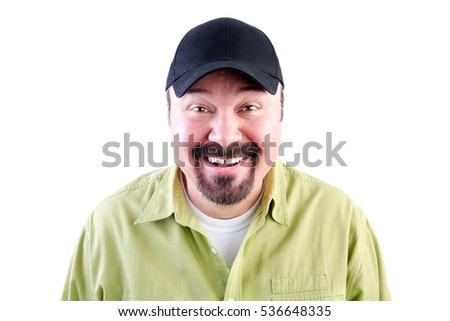 Head and shoulders portrait of grinning man in baseball cap, white background Royalty-Free Stock Photo #536648335