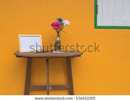photo Frame on a wooden table and Yellow background .