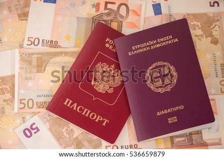 Passports on banknote background. Russian and Greek passports. Euro banknotes 50 fifty. Traveling and money.